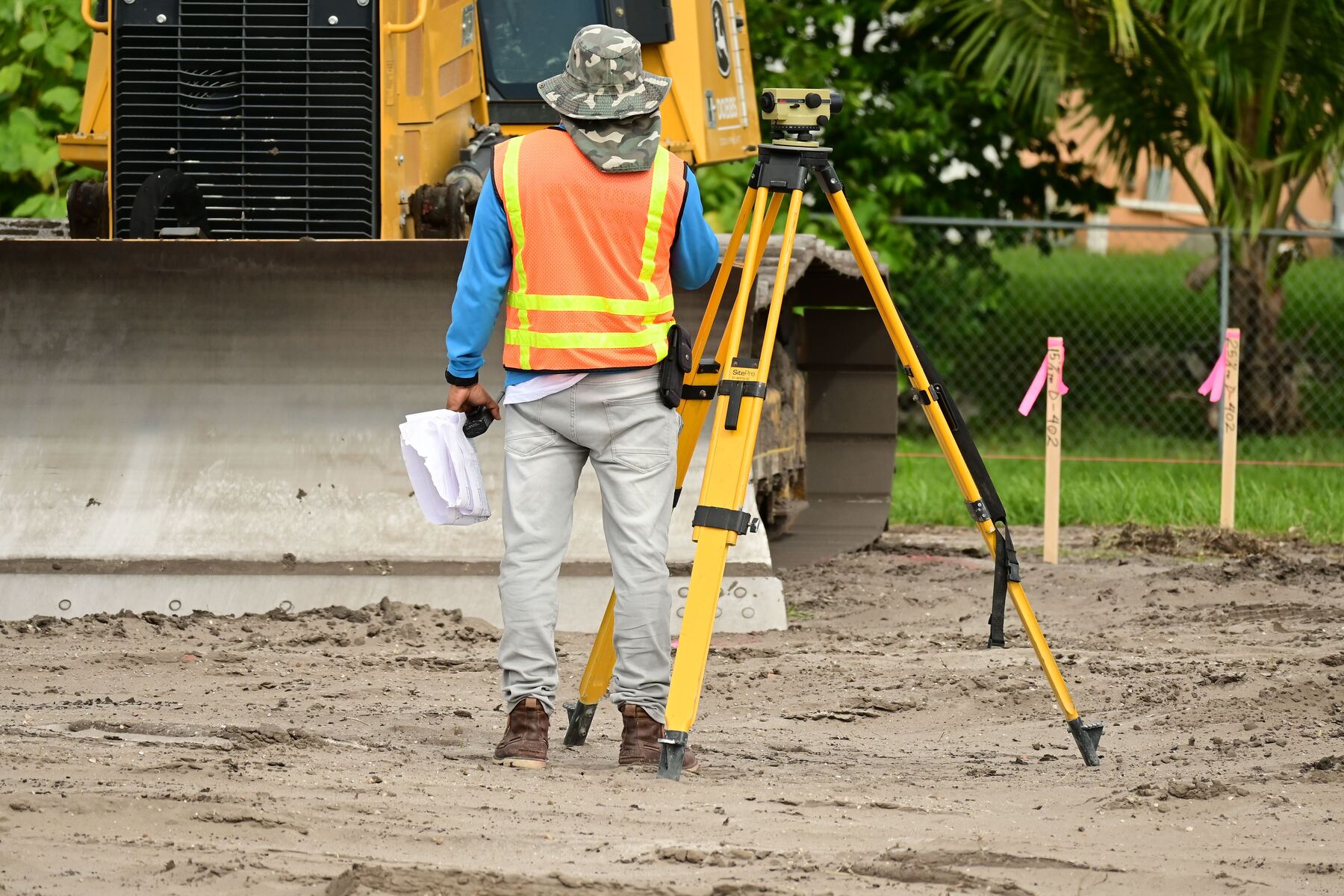 Site surveyor taking precise measurements with a transit level
